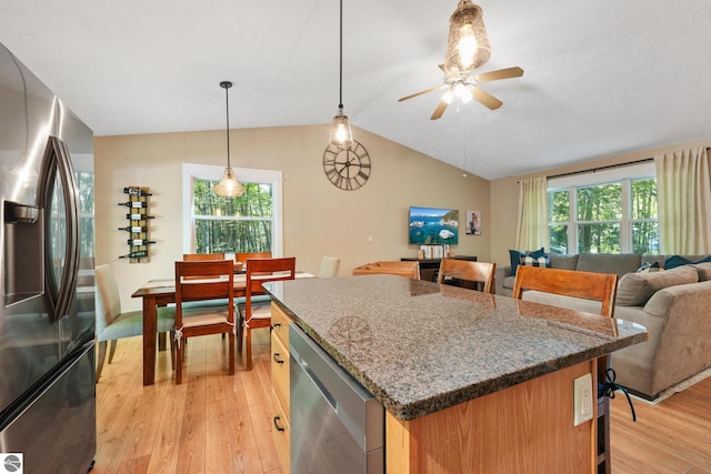 8315 Aimee Ln, Lake Ann, MI 49650 - kitchen with appliances with stainless steel finishes, a kitchen bar, vaulted ceiling, light wood-style flooring, and a kitchen island