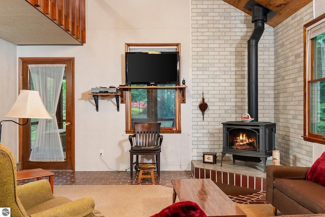 15910 E Cherry Park Dr, Northport, MI 49670 - living area featuring a wood stove, brick wall, and carpet flooring