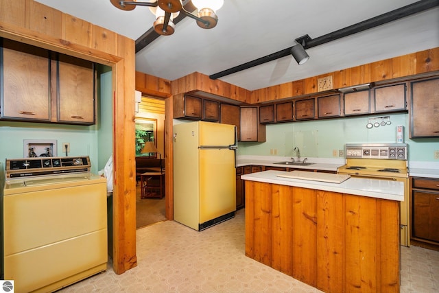 15910 E Cherry Park Dr, Northport, MI 49670 - kitchen featuring white appliances, washer / clothes dryer, light floors, light countertops, and a kitchen island