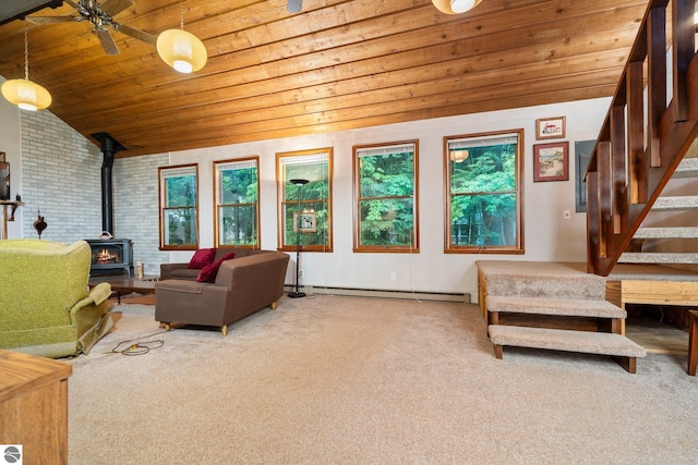 15910 E Cherry Park Dr, Northport, MI 49670 - carpeted living room with wood ceiling, a wood stove, a baseboard radiator, stairs, and vaulted ceiling