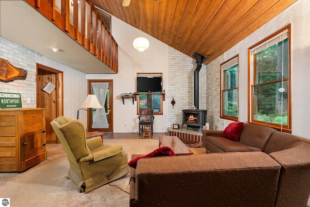 15910 E Cherry Park Dr, Northport, MI 49670 - carpeted living area with brick wall, a wood stove, plenty of natural light, lofted ceiling, and wooden ceiling