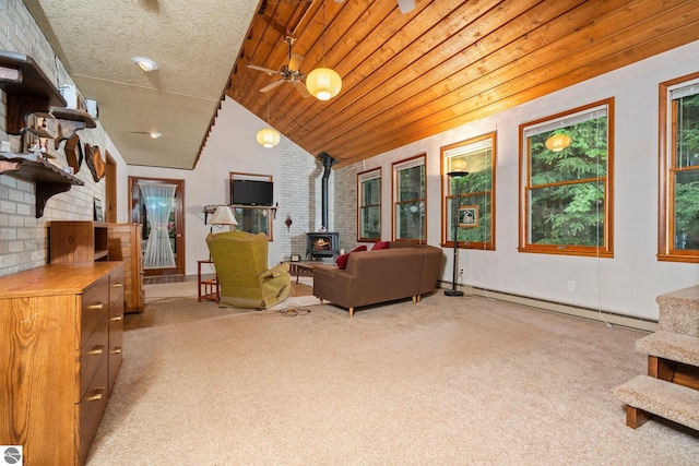 15910 E Cherry Park Dr, Northport, MI 49670 - living area with baseboard heating, a wood stove, light carpet, lofted ceiling, and ceiling fan