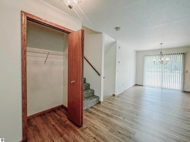 3730 Driftwood Dr, Cadillac, MI 49601 - spare room featuring a chandelier, wood finished floors, stairway, and a smoke detector