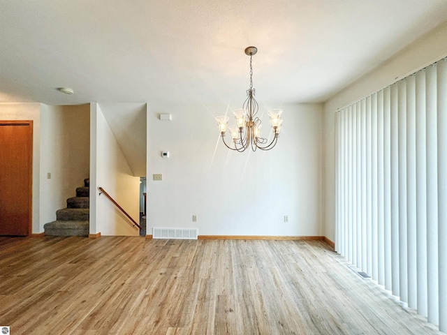 3730 Driftwood Dr, Cadillac, MI 49601 - spare room featuring light wood finished floors, stairway, a chandelier, and a smoke detector