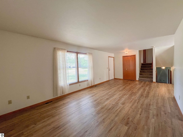 3730 Driftwood Dr, Cadillac, MI 49601 - unfurnished living room featuring wood finished floors and stairs