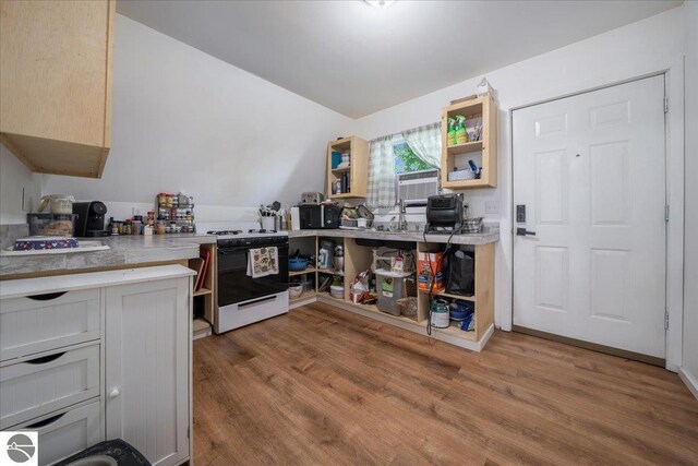100 S Bullock St, Whittemore, MI 48770 - kitchen with stove, wood finished floors, and open shelves
