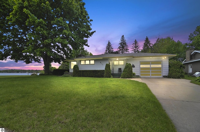 611 Sunset Ln, Cadillac, MI 49601 - view of front of house featuring an attached garage, driveway, and a lawn