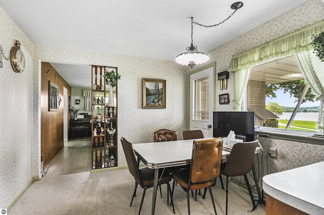 611 Sunset Ln, Cadillac, MI 49601 - dining area featuring wallpapered walls, a water view, and wood finished floors