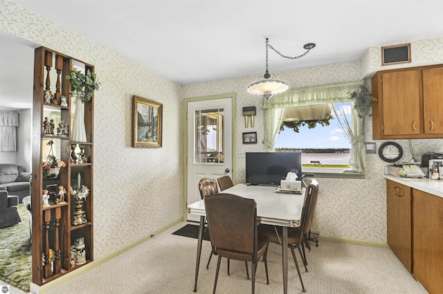 611 Sunset Ln, Cadillac, MI 49601 - dining room featuring wallpapered walls and light colored carpet