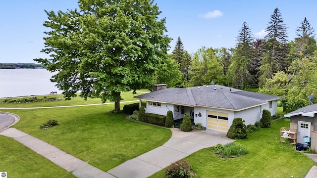 611 Sunset Ln, Cadillac, MI 49601 - single story home featuring concrete driveway, an attached garage, a front yard, a chimney, and a water view