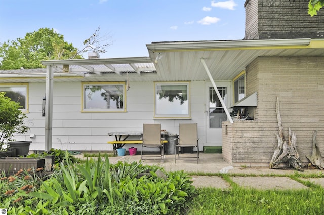 611 Sunset Ln, Cadillac, MI 49601 - rear view of house with a chimney and a patio area