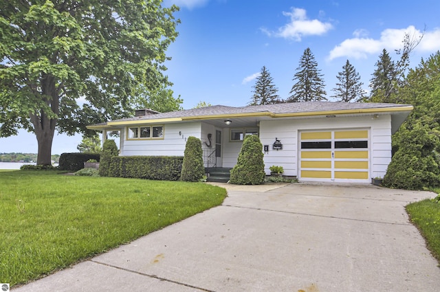 611 Sunset Ln, Cadillac, MI 49601 - view of front of home featuring an attached garage, a front yard, and concrete driveway