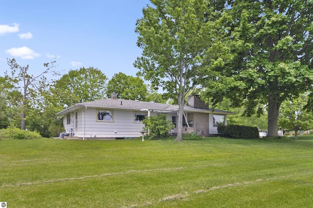 611 Sunset Ln, Cadillac, MI 49601 - back of house featuring a yard