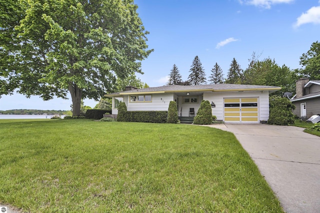 611 Sunset Ln, Cadillac, MI 49601 - view of front of home featuring an attached garage, concrete driveway, and a front yard
