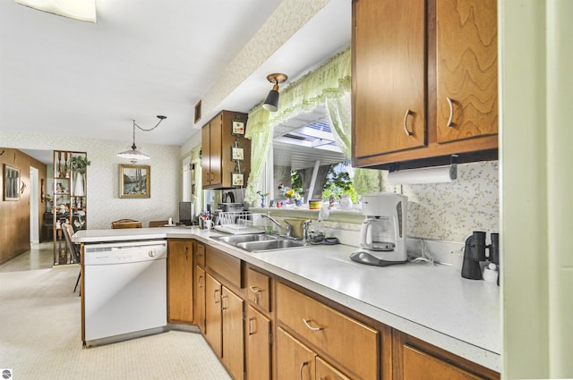 611 Sunset Ln, Cadillac, MI 49601 - kitchen featuring white dishwasher, wallpapered walls, a peninsula, light countertops, and brown cabinetry