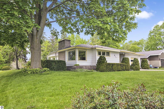 611 Sunset Ln, Cadillac, MI 49601 - ranch-style home featuring a chimney, an attached garage, and a front yard