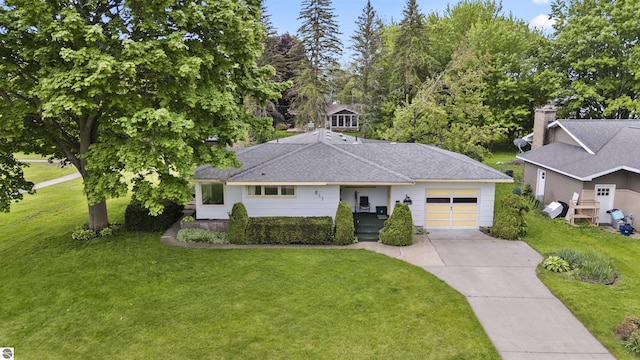 611 Sunset Ln, Cadillac, MI 49601 - ranch-style home featuring an attached garage, concrete driveway, a front lawn, and roof with shingles