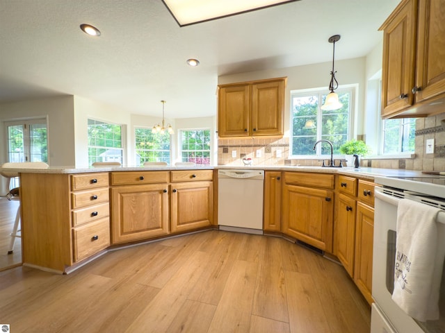318 Red Maple Ln, Shepherd, MI 48883 - kitchen with white appliances, light wood-type flooring, a peninsula, tasteful backsplash, and healthy amount of natural light