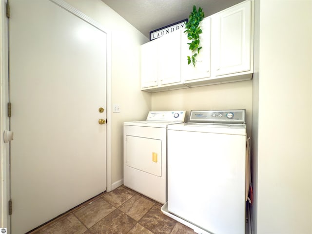 318 Red Maple Ln, Shepherd, MI 48883 - laundry room featuring washing machine and dryer, cabinet space, stone finish floors, and a textured ceiling