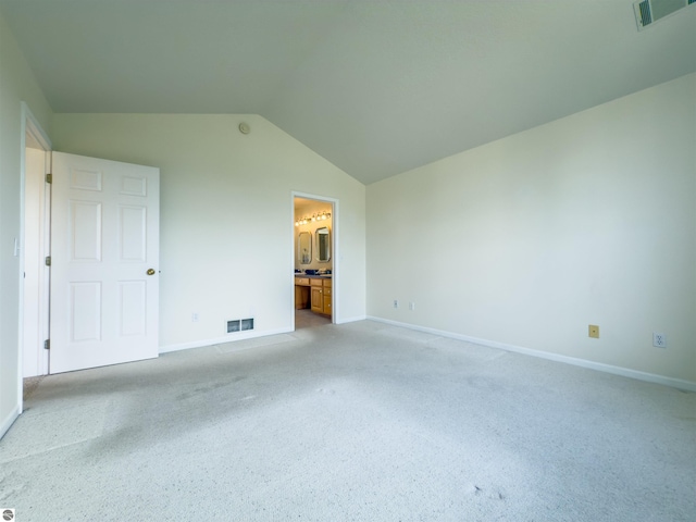 318 Red Maple Ln, Shepherd, MI 48883 - unfurnished bedroom featuring lofted ceiling, light carpet, and ensuite bath