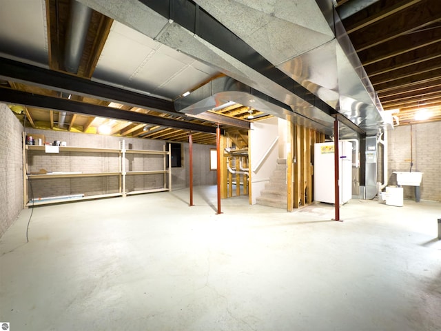 318 Red Maple Ln, Shepherd, MI 48883 - unfinished below grade area featuring stairway, fridge, and brick wall