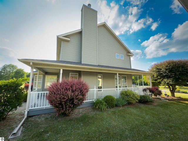 318 Red Maple Ln, Shepherd, MI 48883 - farmhouse featuring covered porch, a chimney, and a front yard