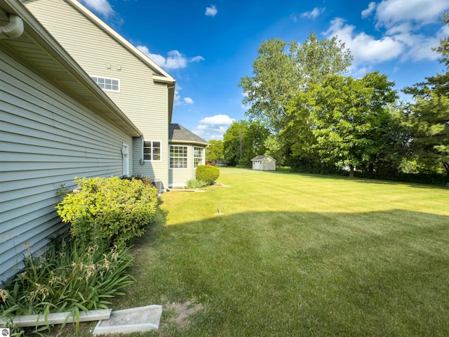 318 Red Maple Ln, Shepherd, MI 48883 - view of grassy yard with a storage shed