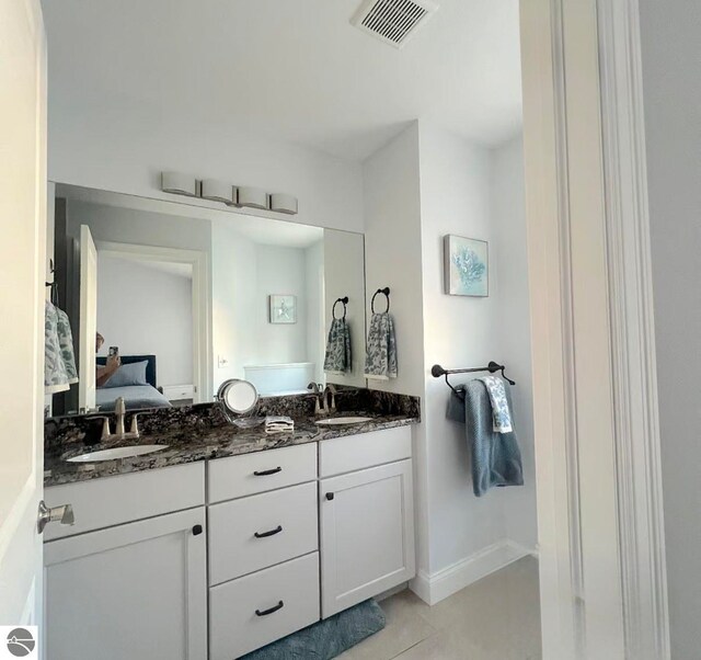 982 Lake Ridge Dr Unit 10, Traverse City, MI 49684 - ensuite bathroom featuring double vanity and tile patterned floors