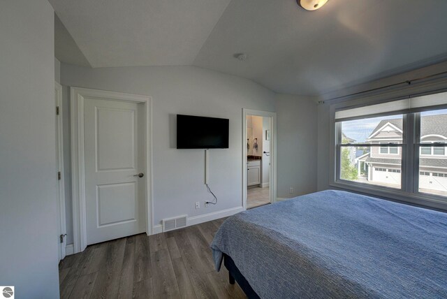 982 Lake Ridge Dr Unit 10, Traverse City, MI 49684 - bedroom featuring lofted ceiling, wood finished floors, and ensuite bathroom
