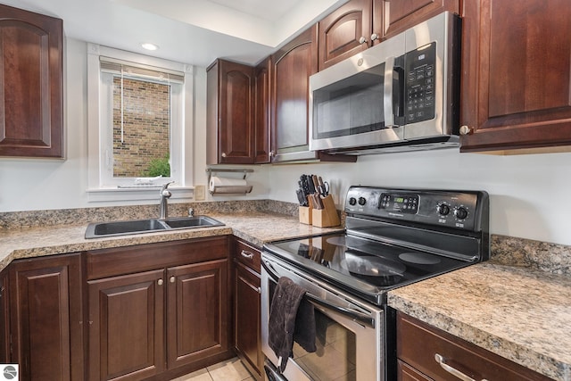 6022 Holt Rd Unit 2, Williamsburg, MI 49690 - kitchen with appliances with stainless steel finishes, light countertops, dark brown cabinetry, recessed lighting, and light tile patterned flooring