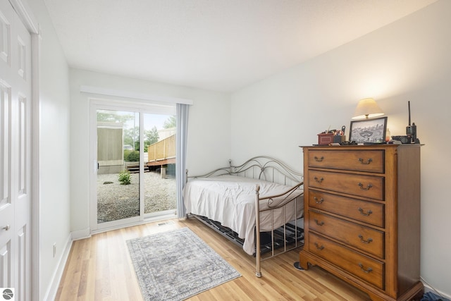 6022 Holt Rd Unit 2, Williamsburg, MI 49690 - bedroom with access to exterior and light wood-style flooring