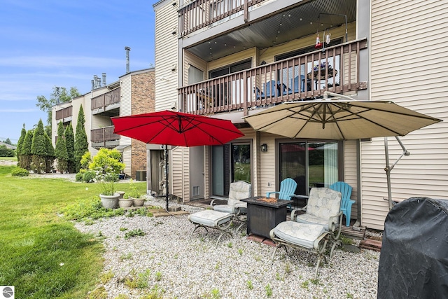 6022 Holt Rd Unit 2, Williamsburg, MI 49690 - back of house featuring a balcony, a fire pit, and a lawn