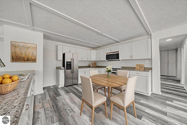 3594 Channel Rd, Hale, MI 48739 - kitchen featuring stainless steel refrigerator with ice dispenser, wood finished floors, a textured ceiling, and white cabinetry