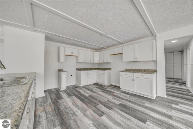 3594 Channel Rd, Hale, MI 48739 - kitchen featuring wood finished floors, a textured ceiling, and white cabinetry