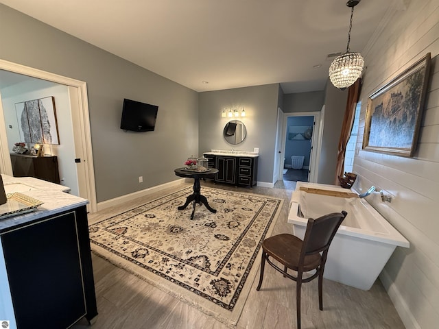 777 Stoneridge Dr, Mount Pleasant, MI 48858 - full bathroom featuring a freestanding tub, vanity, a chandelier, and wood finished floors