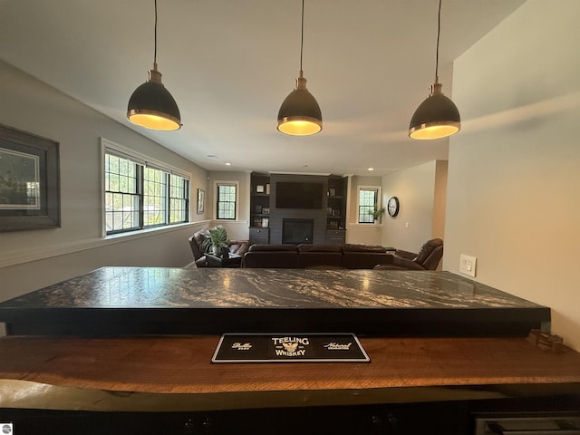 777 Stoneridge Dr, Mount Pleasant, MI 48858 - kitchen with dark countertops, a fireplace, and pendant lighting