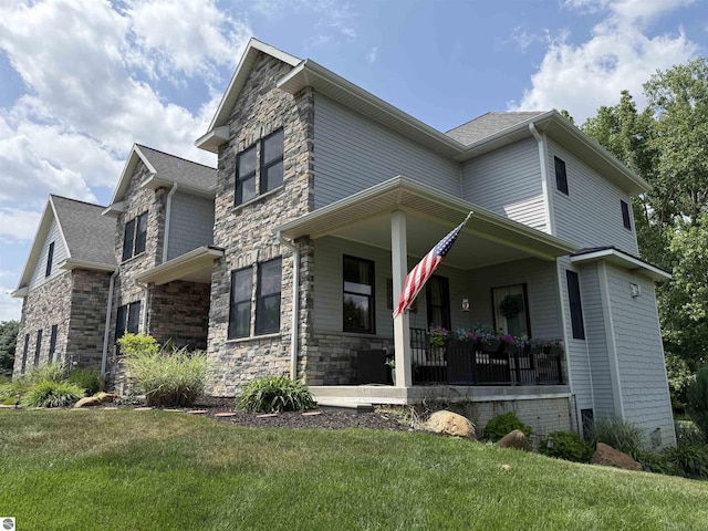 777 Stoneridge Dr, Mount Pleasant, MI 48858 - view of front of house with covered porch, stone siding, and a front yard