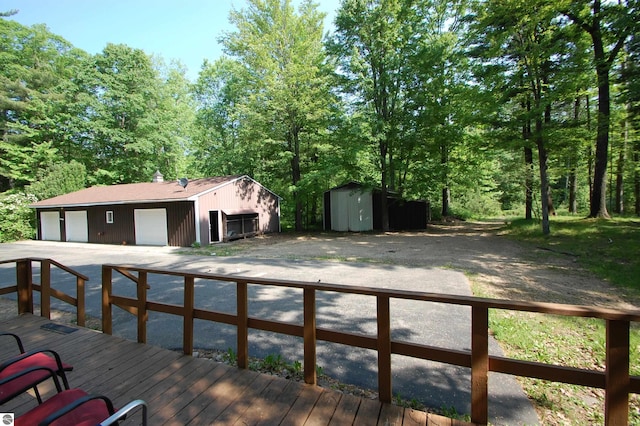 1294 Stoney Ridge Rd, West Branch, MI 48661 - deck featuring a detached garage, a storage shed, and driveway