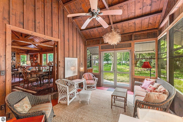 7822 W Welch Rd, Empire, MI 49630 - living room with a wood ceiling with exposed beams, wooden walls, ceiling fan, plenty of natural light, and high vaulted ceiling