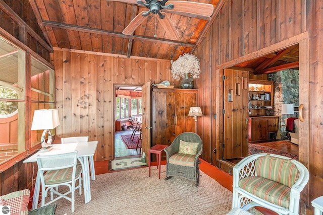 7822 W Welch Rd, Empire, MI 49630 - living area with wooden ceiling, wood walls, a ceiling fan, and carpet floors