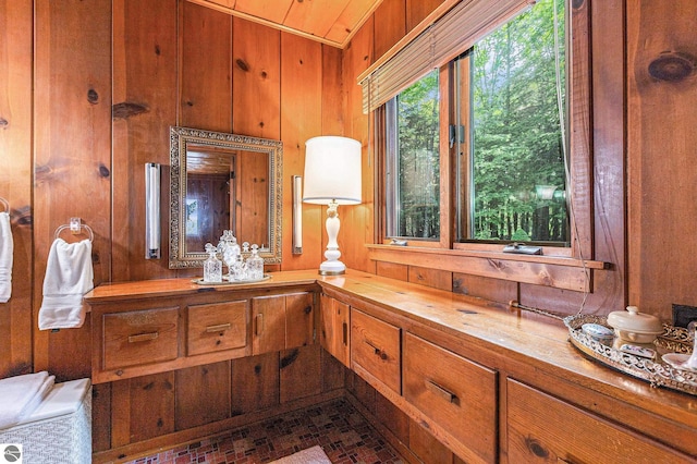 7822 W Welch Rd, Empire, MI 49630 - bathroom featuring wooden walls, vanity, and brick patterned floors