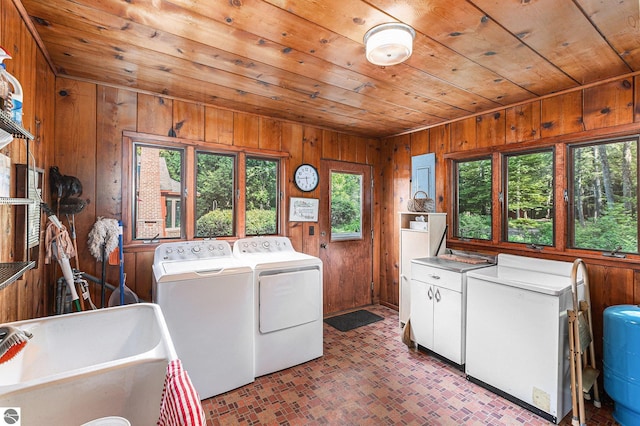 7822 W Welch Rd, Empire, MI 49630 - washroom with washer and dryer, wood ceiling, wood walls, cabinet space, and brick patterned flooring