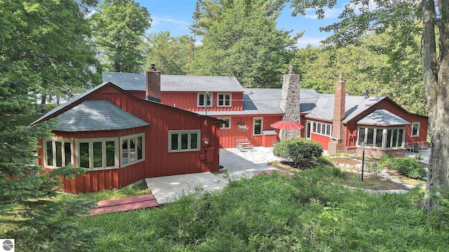 7822 W Welch Rd, Empire, MI 49630 - back of property with a chimney and a patio