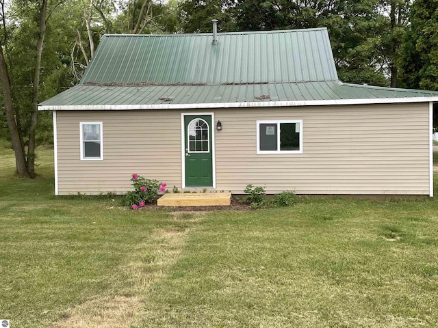 702 N Grafton Ave, Alma, MI 48801 - back of house featuring a yard and view of scattered trees