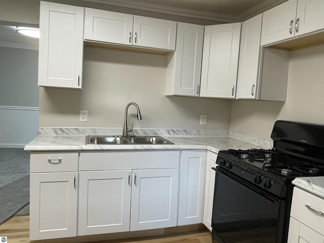 702 N Grafton Ave, Alma, MI 48801 - kitchen with black gas stove, crown molding, white cabinets, and light wood finished floors