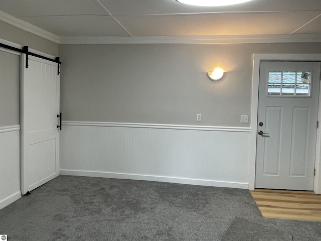 702 N Grafton Ave, Alma, MI 48801 - foyer entrance with carpet floors, a barn door, and crown molding