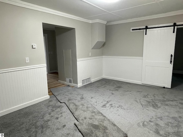 702 N Grafton Ave, Alma, MI 48801 - spare room featuring a barn door, a wainscoted wall, carpet floors, and crown molding
