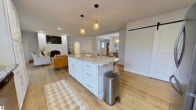 84 9 Mile Rd NW, Comstock Park, MI 49321 - kitchen with appliances with stainless steel finishes, a barn door, arched walkways, white cabinets, and recessed lighting