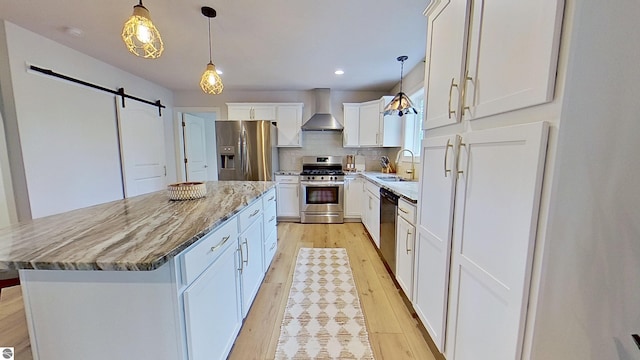 84 9 Mile Rd NW, Comstock Park, MI 49321 - kitchen with stainless steel appliances, wall chimney exhaust hood, a barn door, light wood-type flooring, and recessed lighting