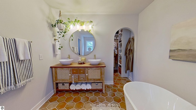 84 9 Mile Rd NW, Comstock Park, MI 49321 - full bath featuring double vanity, a freestanding tub, tile patterned floors, and a spacious closet